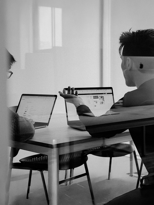 Personen arbeiten im Büro am Laptop